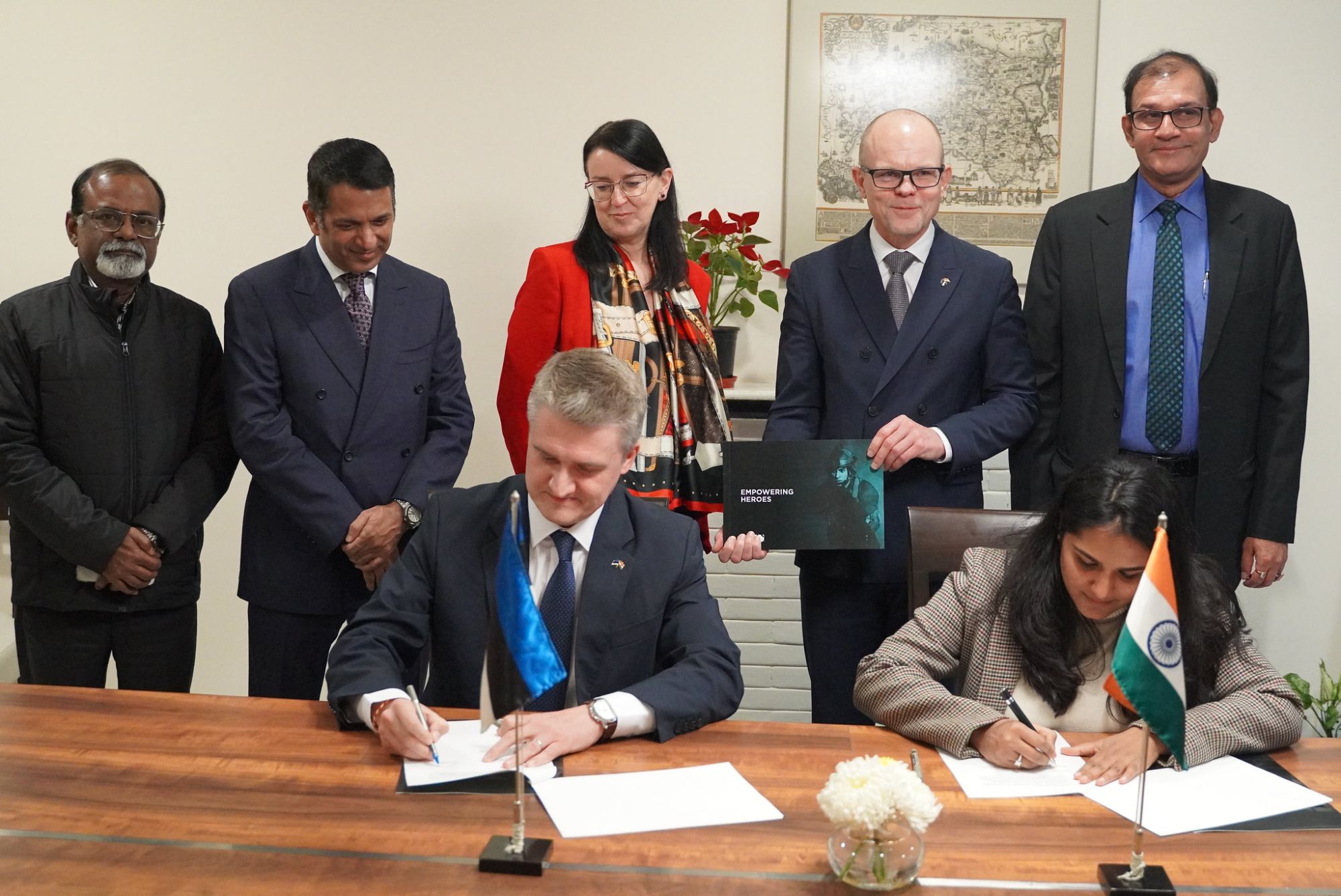 Representatives of Vegvisir and MKU sign the Memorandum of Understanding at a table with Estonian and Indian flags, with guests standing behind them
