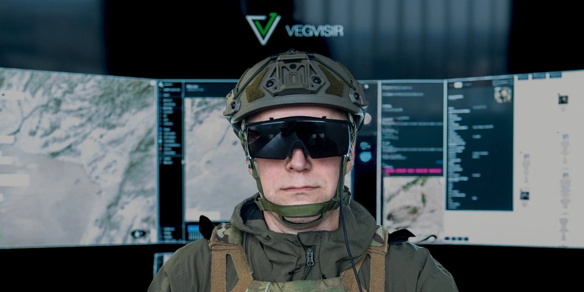 An operator wearing the Vegvisir Visor in front of virtual command screens showing maps and mission data